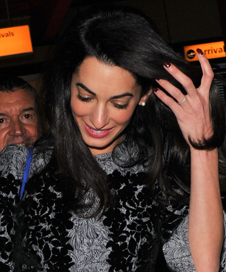 Mrs Amal Clooney shows off her wedding band as she arrives at heathrow airport on November 25, 2014.