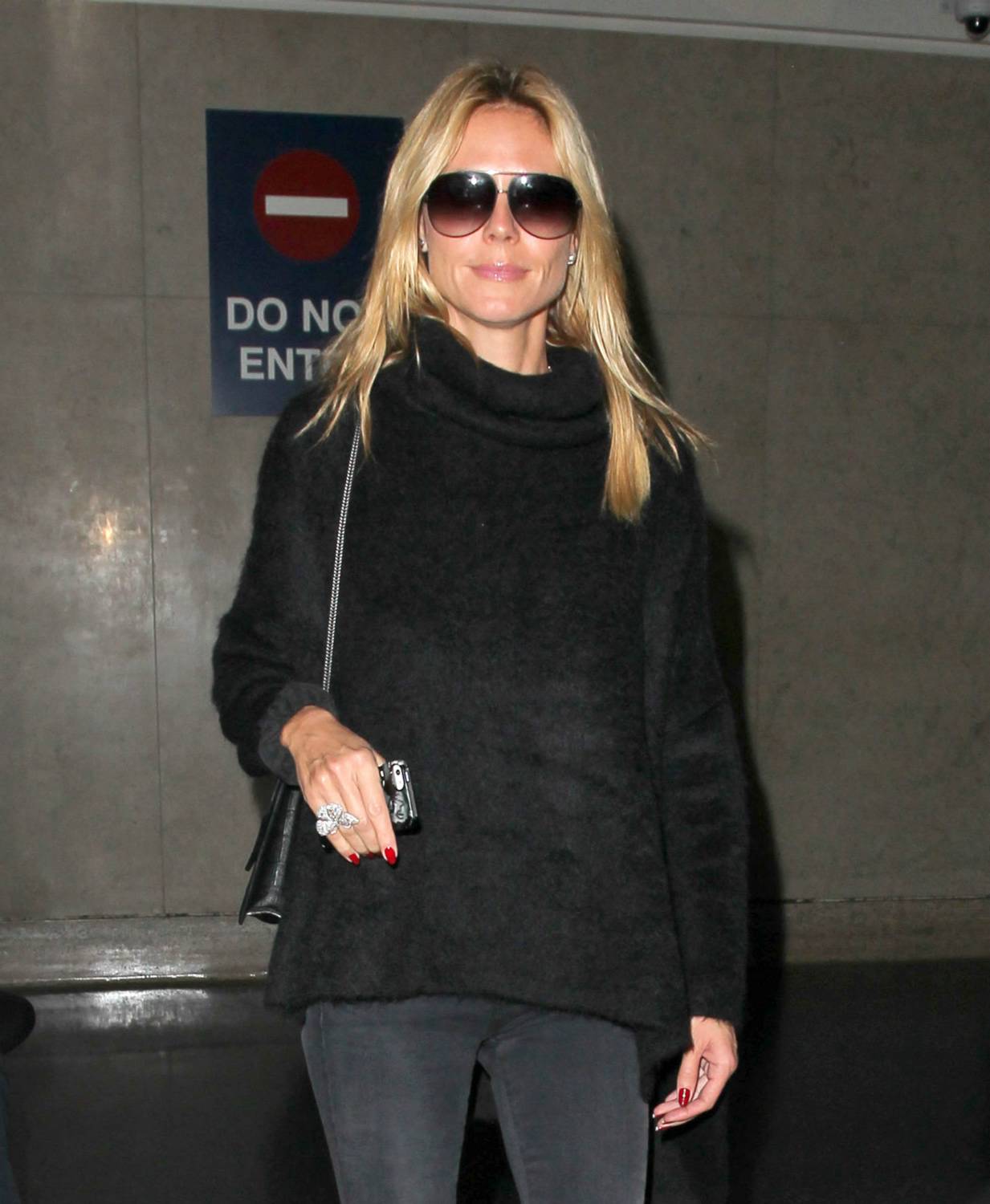 Heidi Klum signs autographs for fans as she arrives on a flight at LAX airport on December 5, 2014 in Los Angeles, California.